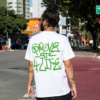 Modelo utilizando camiseta branca escrito "Grove Street 4 Life", referência à gangue de Carl Johson, protagonista do GTA San Andreas
