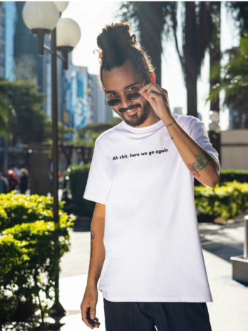 Modelo utilizando camiseta branca da loja Dei Pause escrito "ah shit here we go again"